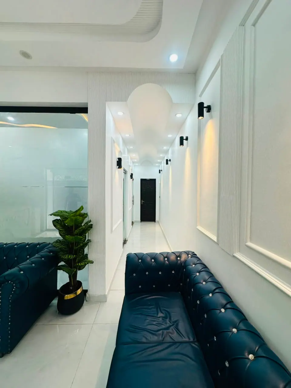 Bright clinic corridor with navy blue Chesterfield sofas
